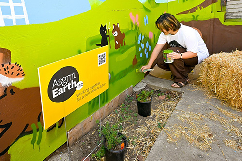 A student works on a mural titled Little Garden for the USC Peace Garden Project.