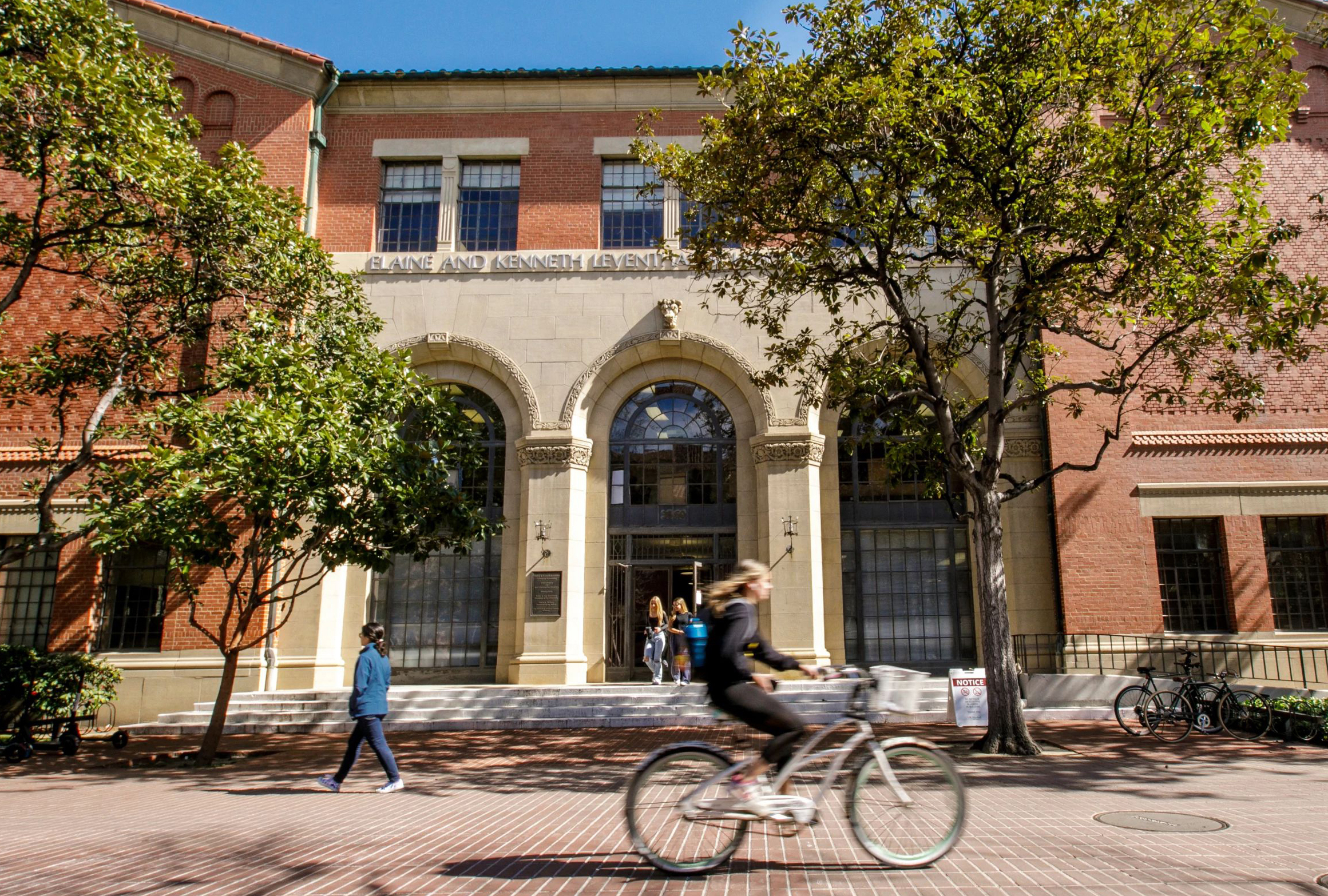 A student cycles by the Accounting building.